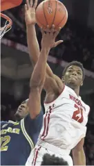  ?? MARY LANGENFELD/USA TODAY ?? Wisconsin guard Khalil Iverson blocks a shot by Michigan guard Muhammad-Ali Abdur-Rahkman.