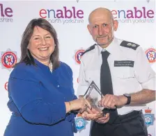  ?? ?? Simon Cossins receives his award from Crime Commission­er Zoë Metcalfe.