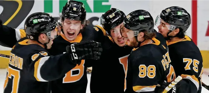  ?? STuART CAHiLL pHoTos / HeRALd sTAFF ?? TAKE TWO: David Pastrnak (88) celebrates his goal in the first period against the Islanders with Patrice Bergeron (37), Mike Reilly (6), Brad Marchand (63) and Connor Clifton (75) at the Garden on Friday night.