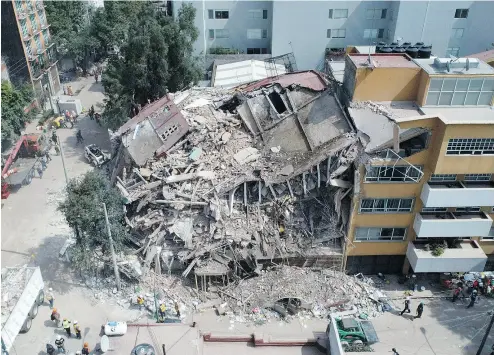  ?? MARIO VAZQUEZ / AFP / GETTY IMAGES ?? The search for survivors continues in a flattened building in Mexico City after a 7.1-magnitude earthquake hit central Mexico. The bodies of more than 200 victims have been found so far.