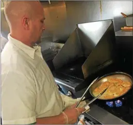  ?? ANDREW CASS — THE NEWS-HERALD ?? Chef James Garrison prepares Dino’s signature dish, chicken piccata. Dino’s Restaurant has been at its 1200 E. 305th St., Willowick location since 1978.