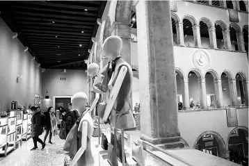  ??  ?? Visitors walk in ‘IL Fondaco dei Tedeschi’ the new luxury mall inside a historical building in Venice, near the Rialto Bridge. Italy needs to step up reforms if it is to make a full recovery from an economic crisis that caused poverty and inequality to...