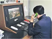  ??  ?? A South Korean government official checks the direct communicat­ions hotline to North Korea at the border village of Panmunjom. Korean media reported that the line was reopened yesterday