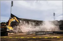  ?? CHAD RHYM / CHAD.RHYM@AJC.COM ?? After a farewell event, members of the audience witness a ceremonial destructio­n Tuesday. The tennis center, an eyesore since its use during the 1996 Olympics, was recently procured by the county for the express purpose of leasing/selling/partnering...