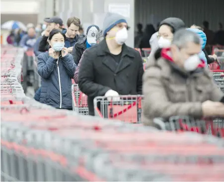  ??  ?? People wait in line to enter a Costco store in Toronto. Experts say spending habits are guided in part by the need for control, schedule changes and even boredom.