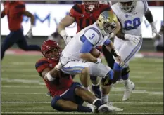  ??  ?? Arizona defensive end Kylan Wilborn sacks UCLA quarterbac­k Josh Rosen (front center) during the second half of an NCAA college football game Saturday in Tucson, Ariz. AP PHOTO/RICK SCUTERI