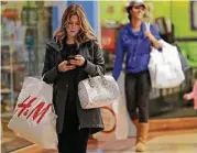  ?? Chuck Burton / Associated Press ?? This shopper was at a mall in Concord, N.C., this week. Holiday spending is surging, a report says.