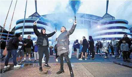  ?? — AP ?? Party time: Manchester City supporters celebratin­g outside the Etihad after their team clinched the English Premier League title.