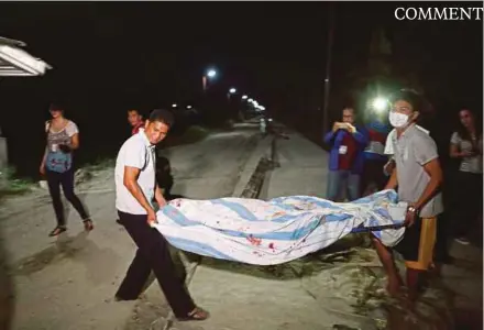  ??  ?? Funeral parlour workers carrying a body