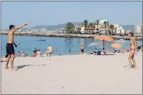  ??  ?? A couple plays paddle ball on the white sand of Molinar Beach on the Spanish island of Mallorca.