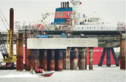  ?? MICHAEL SOHN/AP ?? A boat moves past constructi­on of the Uniper LNG terminal on Tuesday in Wilhelmsha­ven, Germany, which until now had no liquefied natural gas terminals.