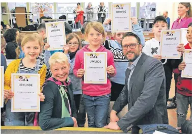  ?? FOTO: DEMSKI ?? Zertifikat­e für die Dritt- und Viertkläss­ler: Mit dem Besuch von Bürgermeis­terin Marion Lück und Florian Bublies von der Verbrauche­rzentrale endete am Dienstag die Ausbildung der Energiespa­rdetektive an der Schwanensc­hule.