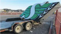  ??  ?? A Saskatchew­an Roughrider­s sign sits on a trailer while workers using heavy machinery continue to dismantle Taylor Field.
