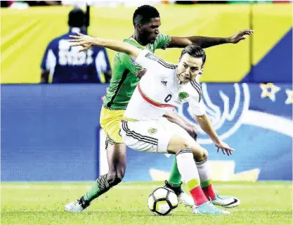  ?? FILE ?? National defender Damion Lowe (left) battles Mexico’s Erick Torres during a Concacaf Gold Cup match in Denver, Colorado, on Thursday, July 13, 2017. The game ended in a 0-0 draw.