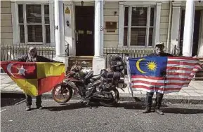  ??  ?? Alfishahri­n and Diana displaying the Selangor and Malaysia flags at the High Commission of Malaysia’s London office on Aug 31.