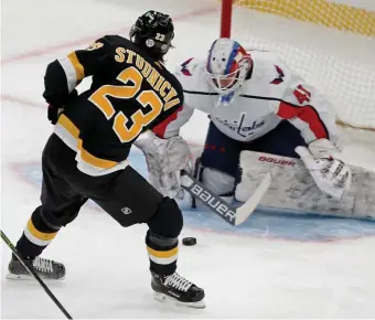  ?? STuART cAHiLL pHOTOs / HERALd sTAFF ?? FINDING HIS COMFORT ZONE: Bruins center Jack Studnicka takes a shot on Capitals goaltender Vitek Vanecek at TD Garden on Friday night. Below, Capitals defenseman Justin Schultz hits Bruins center Trent Frederic on Friday.