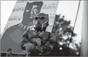  ?? Ap-brynn anderson ?? Mason Wilkes, 4, of South Carolina, poses for his father in a Black Panther costume, in front of a painting during a Chadwick Boseman Tribute on Thursday in Anderson, S.C.