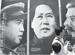  ?? AP Photo/Lee Jin-man ?? In this May 21, 2010, file photo, visitors look at posters of the late leaders, from left, of North Korea’s Kim Il Song, China’s Mao Zedong and Russia’s Joseph Stalin at a Korean War exhibition in Seoul, South Korea.