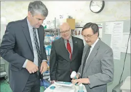  ?? DARRELL COLE/TC MEDIA ?? Veteran physician Dr. Brian McFarlane looks over a piece of hospital equipment with Nova Scotia Premier Stephen McNeil and Cumberland North MLA Terry Farrell. The premier announced Tuesday his government will be issuing a request for proposals for a...