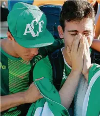  ?? Nelson Almeida/AFP Photo ?? Torcedor consola amigo na Arena Condá ontem, após acidente que vitimou a equipe de Chapecó