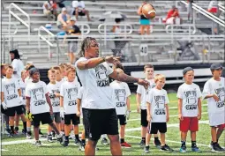  ??  ?? Benny Snell Jr., who was drafted in April by the Pittsburgh Steelers, throws a pass to a youngster during his football camp at Westervill­e Central High School. Snell said he hopes to be someone kids can look up to.