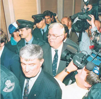  ?? SALTWIRE NETWORK FILE ?? John Crosbie, as federal fisheries minister on July 2, 1992, is escorted by police officers through a mass of media and fishermen in a downtown St. John’s hotel, where he announced a moratorium on fishing northern cod.