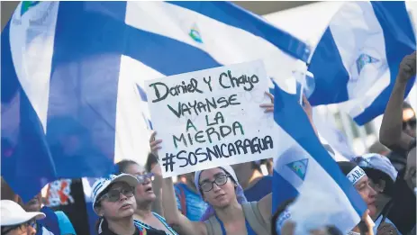  ?? Efe ?? OPOSICIÓN. Una mujer muestra una pancarta en una protesta contra Ortega en las afueras de la Universida­d Centroamér­icana.