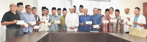  ??  ?? UNTUK ALBUM: Abang Johari (tengah) merakamkan gambar kenangan bersama wakil masjid dan surau bagi kawasan N.8 Satok yang menerima sumbangan Ramadan semalam.