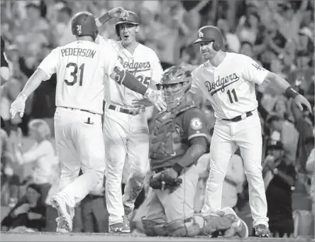  ?? Christian K. Lee Los Angeles Times ?? JOC PEDERSON IS GREETED at home plate by Cody Bellinger and Logan Forsythe (11) after his three-run home run gave the Dodgers a 4-0 lead in the sixth inning. It was the fifth homer for Pederson since he returned June 13 from a concussion.