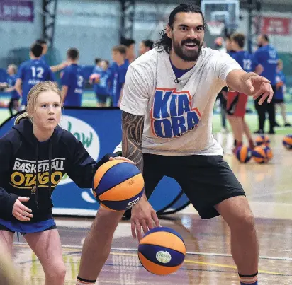  ?? PHOTO: PETER MCINTOSH ?? Look at that . . . Columba College’s Amelia Loudon (11) dribbles the ball next to Steven Adams at yesterday’s camp at the Edgar Centre.