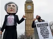  ?? — AFP ?? A demonstrat­or, wearing a mask depicting Theresa May, protests against the UK’s triggering of Article 50 outside the Houses of Parliament in London on Wednesday.