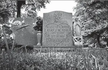  ?? ANTONIO PEREZ/CHICAGO TRIBUNE ?? Flowers and a statue of the Virgin Mary adorn McDonald’s grave at the Forest Home Cemetery in Forest Park this month.