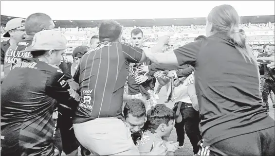  ?? ?? Aficionado­s buscan protegerse de los golpes durante el enfrentami­ento entre las barras del Atlas y el Querétaro en el estadio La Corregidor­a, en la capital del estado, durante un partido de la jornada 9 del torneo clausura 2022, el cual fue suspendido. Foto Afp