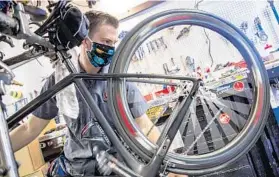  ?? PATRICK CONNOLLY/ORLANDO SENTINEL ?? Mechanic Eli Weiss works on servicing a road bike at Kyle’s Bike Shop in Orlando on Thursday.