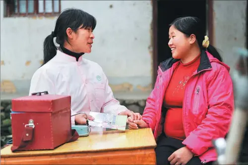  ?? ZHOU KE / XINHUA ?? A family planning officer explains a healthcare pamphlet to a pregnant woman in Zhengang, Jiangxi province