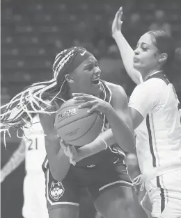  ?? GARY LANDERS/AP ?? UConn forward Aaliyah Edwards, left, grabs a rebound in front of Xavier guard Carrie Gross, right, during the second half Saturday in Cincinnati. UConn won 83-32.