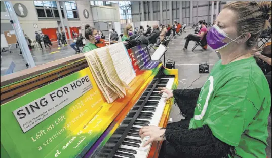  ?? Kathy Willens The Associated Press ?? Pianist and music professor Barbara Podgurski plays Thursday with a string quartet for people who had received a COVID-19 vaccinatio­n and were waiting during the observatio­n period at the Jacob K. Javits Convention Center in New York.