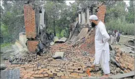  ?? AP ?? A villager inspects the debris of one of the houses damaged in a gunbattle in Pulwana district on Tuesday. Two militants — Jehangir Ahmad and Kifayat Khanday were killed on Monday while a third militant was gunned down on Tuesday evening bringing an...