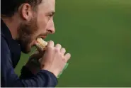  ?? (AP Photo/Charlie Riedel) ?? A patron eats a pimento cheese sandwich during a practice round in preparatio­n for the Masters golf tournament at Augusta National Golf Club, April 9 in Augusta, Ga.