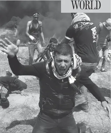  ?? ADEL HANA / THE CANADIAN PRESS ?? Palestinia­n protesters fall down from tear gas fired by Israeli troops after they burn tires during a protest at the Gaza Strip’s border with Israel, east of Khan Younis, on Friday.