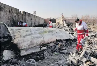  ??  ?? Rescue workers search through wreckage after a Ukrainian plane crashed in Shahedshah­r, southwest of Tehran, on Jan. 8.