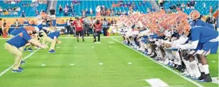  ?? MARK BROWN/GETTY ?? Gators staff lead players through warms up before their Orange Bowl matchup with Virginia.