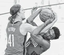  ?? John Raoux / Associated Press ?? Rockets forward Kelly Olynyk, who had 24 points and seven rebounds, battles Magic forward Robert Franks for the ball during the first half Sunday.