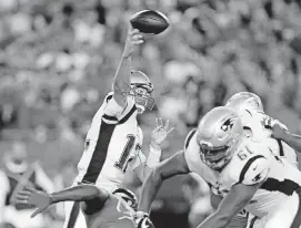  ?? [AP PHOTO] ?? New England quarterbac­k Tom Brady, left, throws under pressure on Thursday night against Tampa Bay.