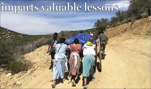  ?? PHOTO COURTESY OF LACHELLE COOK ?? LEFT TO RIGHT: Ivette Guzman, Anebelle Ibarra, Nicole Blanco, Shelby Rolfe and Cynan Eggers work together to push a wooden handcart during Mormon trek reenactmen­t that took place throughout Blair Valley in Ocotillo from April 5 to April 7.