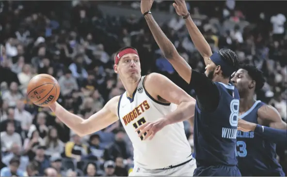  ?? DAVID ZALUBOWSKI/AP ?? DENVER NUGGETS CENTER NIKOLA JOKIC the first half of a game on April in Denver. looks to pass the ball as Memphis Grizzlies guard Ziaire Williams (front) and forward Jaren Jackson Jr. defend during