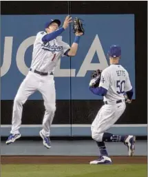  ?? Gina Ferazzi Los Angeles Times ?? AJ POLLOCK, left, makes a leaping catch at the warning track in the series opener. Pollock homered in the seventh inning and was intentiona­lly walked to load the bases in the eighth.