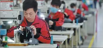  ?? XINHUA ?? Employees make sportswear at a workshop of Anta Group in Jinjiang, Fujian province.