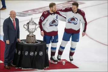  ?? AMBER BRACKEN — THE CANADIAN PRESS ?? The Avalanche's Gabriel Landeskog (92) and Erik Johnson (6) stand with the Campbell Conference Bowl as Deputy Commission­er Bill Daley looks on after overtime conference finals action in Edmonton, Alberta on Monday.