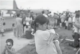  ?? DITA ALANGKARA/THE ASSOCIATED PRESS ?? Canada’s disaster team heading for Iloilo can expect to find scenes such as this in Tacloban, where a survivor of typhoon Haiyan, which hit last Friday, weeps as she holds her daughter while waiting to get on a U.S. air force plane to flee to the...